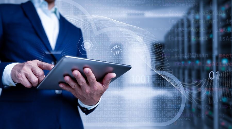 IT professional using a tablet to monitor data center infrastructure through DCIM software.