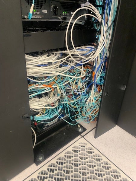 Photo: Years of growth pushed cable managers past their limits—doors wouldn’t close, fingers were buried, and serviceability was lost. 
