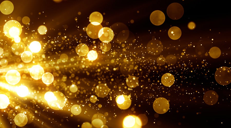 Golden bokeh lights on a dark background, creating a festive and elegant atmosphere.