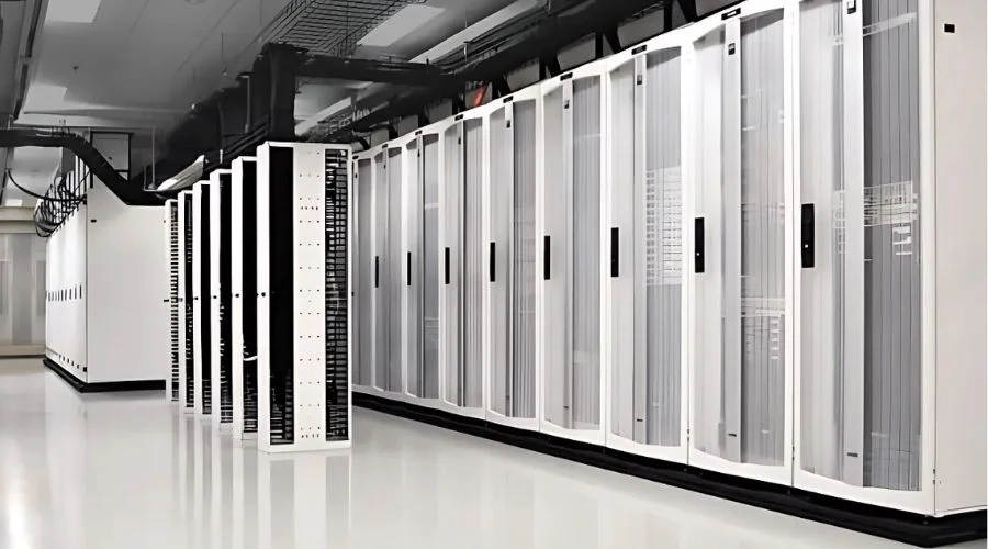 Row of white data center cabinets with clear front doors in a brightly lit, clean facility.