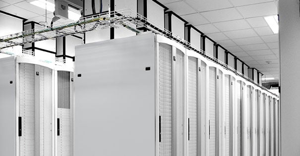 Row of server cabinets in a data center with overhead cable management.